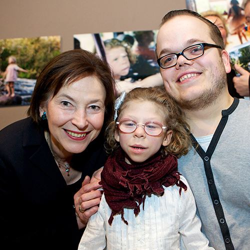 Eva Luise Köhler lächelt gemeinsam mit Josephine Schulz und Michael Wächter bei der Eröffnung einer Fotoausstellung in die Kamera.