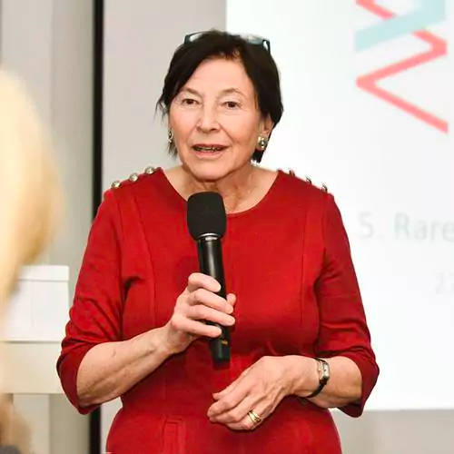 Eva Luise Köhler spricht mit Mikrophon in rotem Kleid